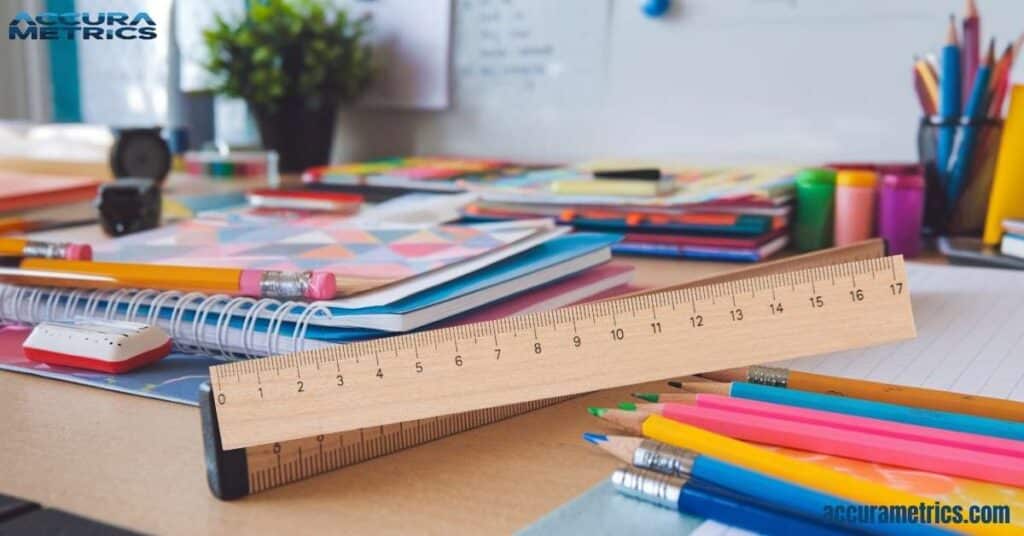 A classic wooden school ruler on a desk with colorful school supplies.