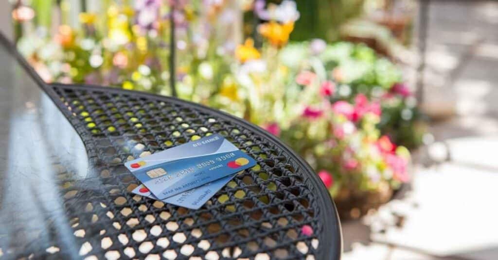 Two credit cards overlapping on a patio table.