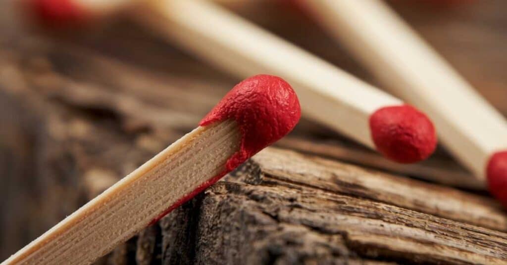 A clear image of a safety match stick resting on a wooden table.