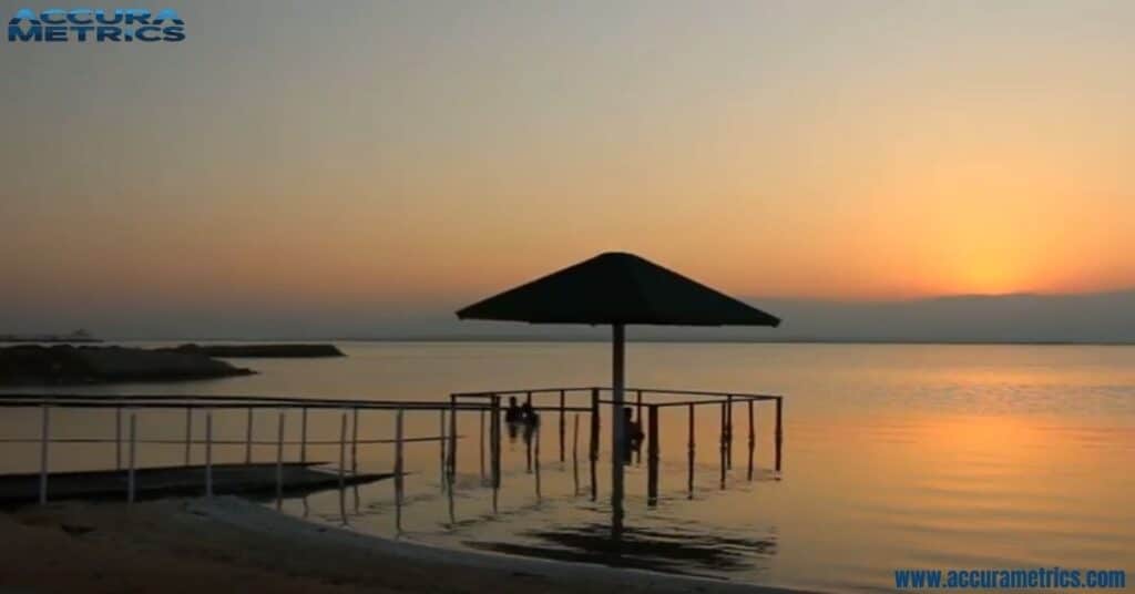 Dead Sea at sunrise, highlighting turquoise waters, white salt formations, and surrounding desert terrain