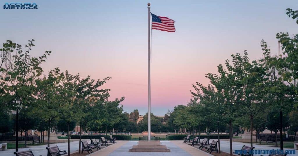 A 20 ft flagpole with a flag waving in the park.